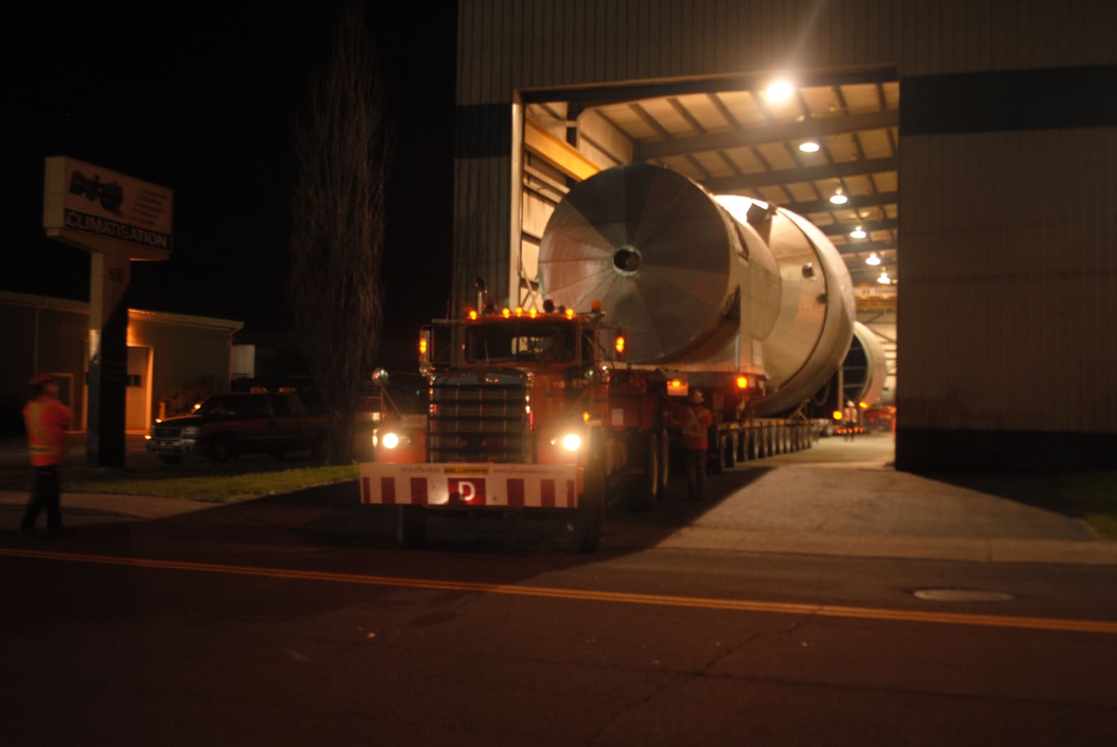 transport truck going out of a fabrication shop with a uge steel componenet