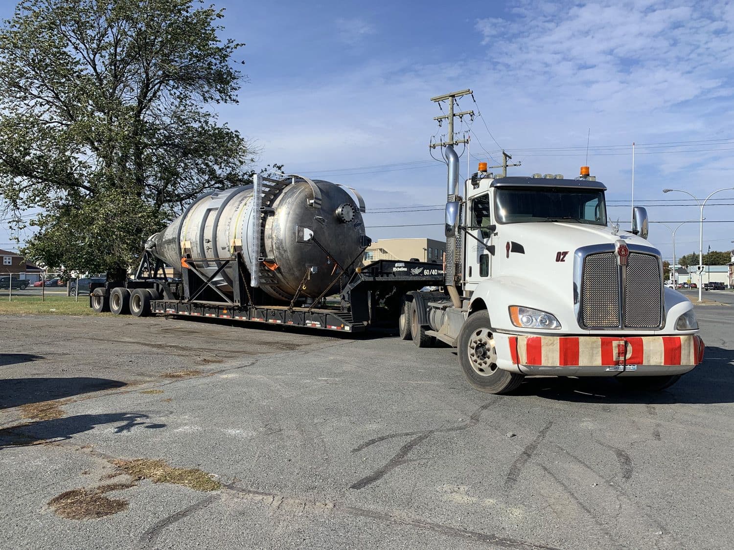 Gros camion qui traîne un énorme fardier sur une plateforme